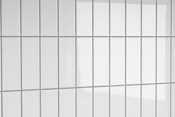 White, glossy subway tiles arranged vertically with gray grout.