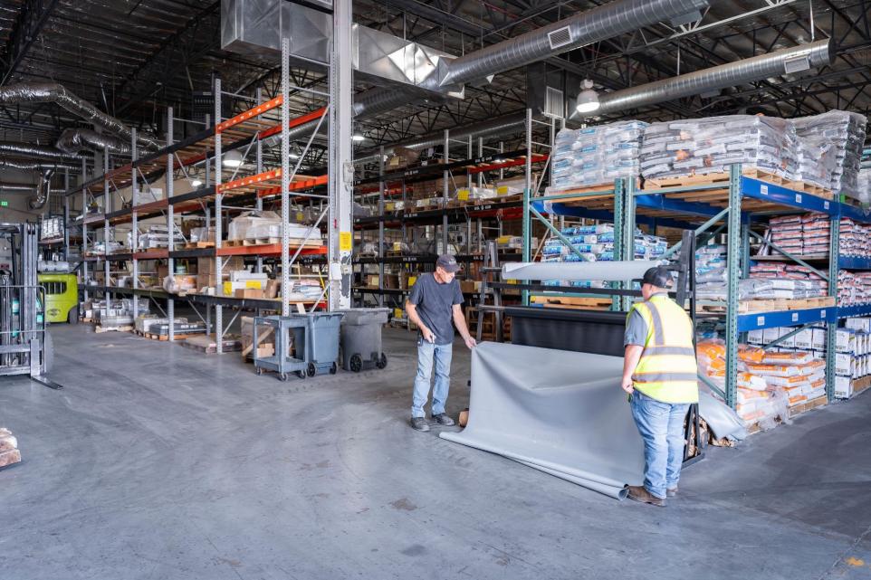 Warehouse with tile installation supplies and team members assisting customers at Nova Tile and Stone Minden