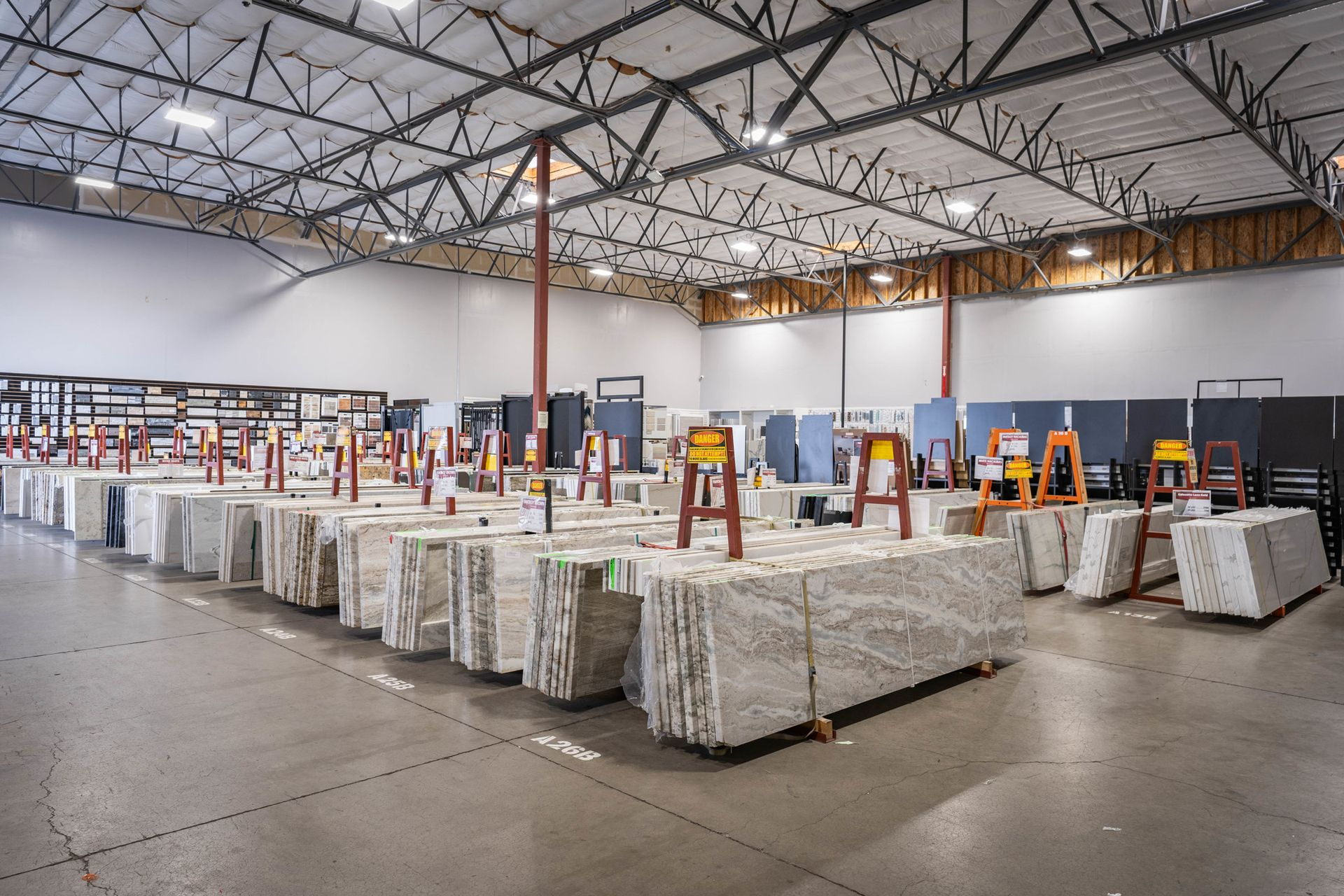 Wide view of granite and quartzite slab selection on A-frame racks at Nova Tile and Stone Minden Nevada