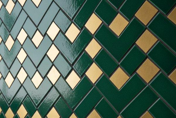 A wall design featuring subway tiles arranged in a complex pattern combining diagonal lay and a centered diamond pattern with light-colored grout