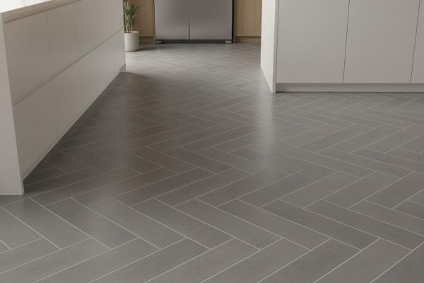 Porcelain subway tiles installed in herringbone pattern on modern kitchen floor