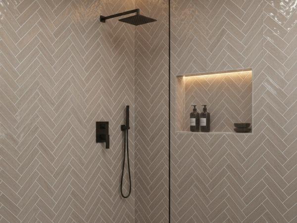 Bathroom shower wall featuring beige glass subway tiles in herringbone layout