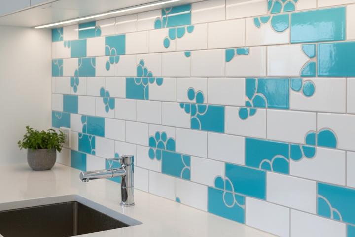 Random dispersion pattern featuring white subway tiles with scattered turquoise accent tiles creating organic custom backsplash design
