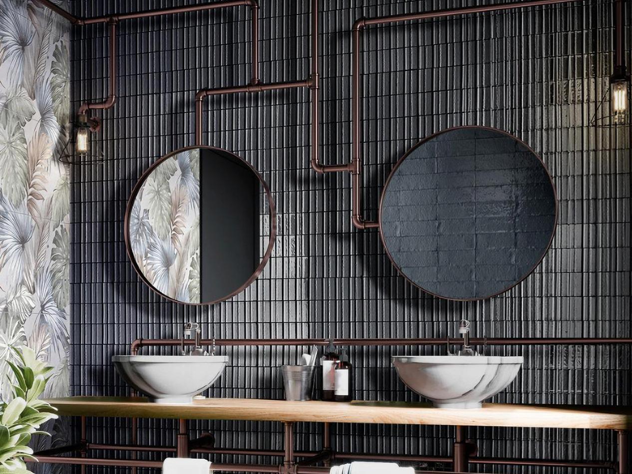 An industrial-style bathroom featuring a wall of small format, dark grey subway tiles s