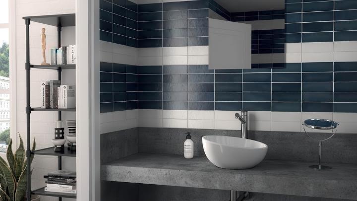 Modern bathroom accent wall using horizontal stripes of white and dark blue subway tile, maximizing white subway tile design in a bold, contemporary pattern.