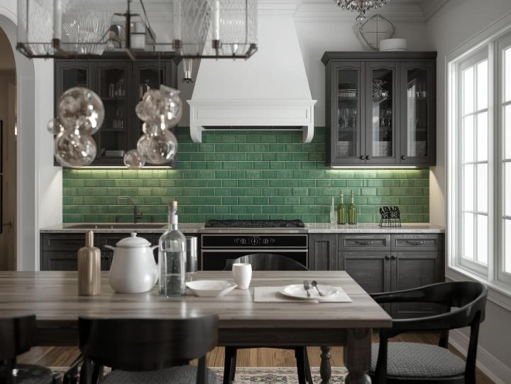 Dark kitchen with a green subway tile backsplash in a running bond arrangement, over a wooden dining table.