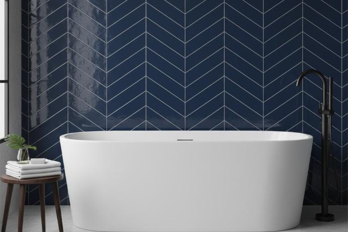 Colored subway tiles in navy blue arranged in chevron pattern behind freestanding bathtub