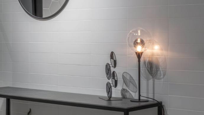 A modern interior space with a wall tiled in 3x12 imagine subway tiles.