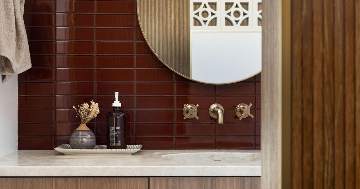 Brown subway tile backsplash in modern bathroom vanity area
