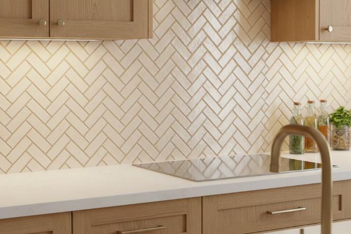 Vintage 2x4 subway tile in herringbone pattern installation on modern kitchen backsplash with warm gray grout
