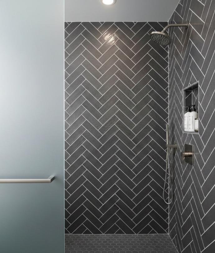 Ceramic 2x4 subway tile in charcoal grey with contrasting white grout creating geometric pattern on bathroom shower wall