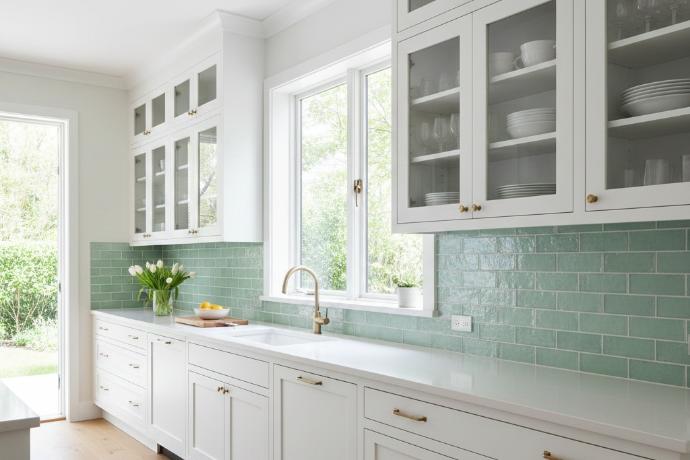 Kitchen with mint green backsplash and white cabinets