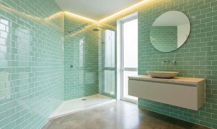 Glossy mint green ceramic subway tiles in modern bathroom
