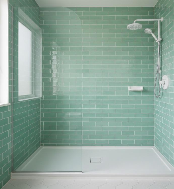 Mint green subway tile shower surround with white fixtures