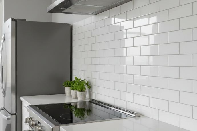 2x4 subway tiles installed in classic running bond pattern on modern kitchen backsplash with white countertop