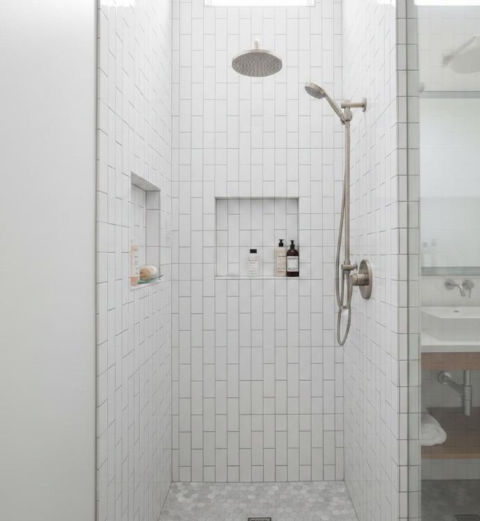 Vertical running bond pattern using 2x4 subway tile in contemporary bathroom shower creating height illusion
