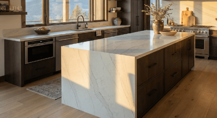 A high-end mountain modern kitchen centering on a large island with a sleek quartz countertop