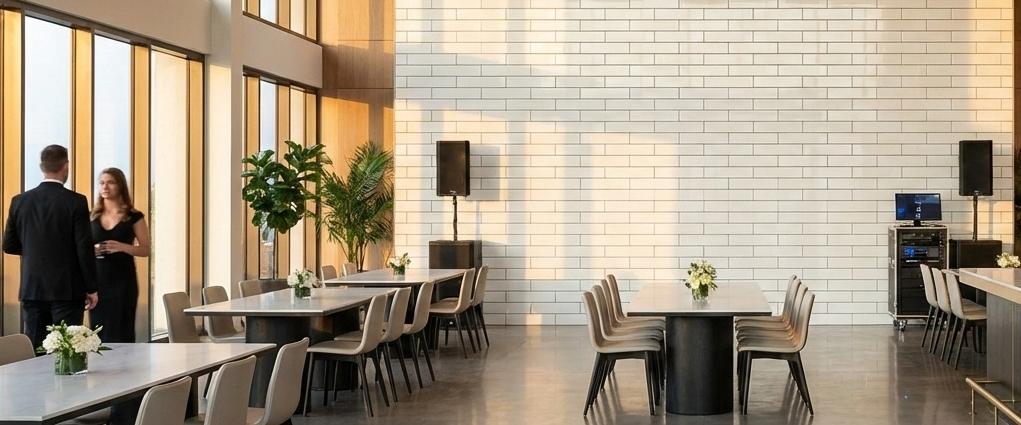 Wide, sunlit dining hall featuring a massive feature wall made of white 3x9 subway tiles in a horizontal arrangement.