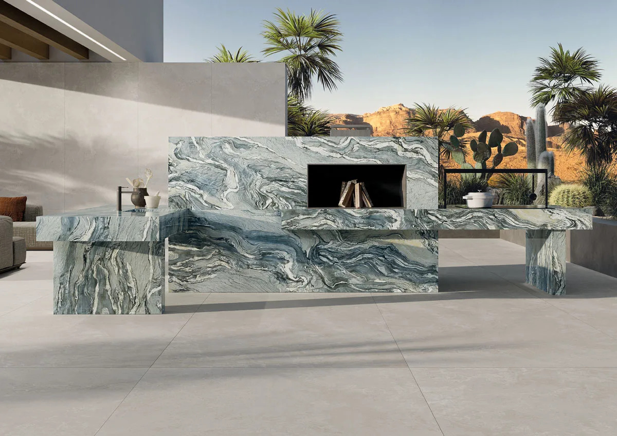 Outdoor kitchen featuring Iconic Cipollino Porcelain Slabs with built-in fireplace and desert view.