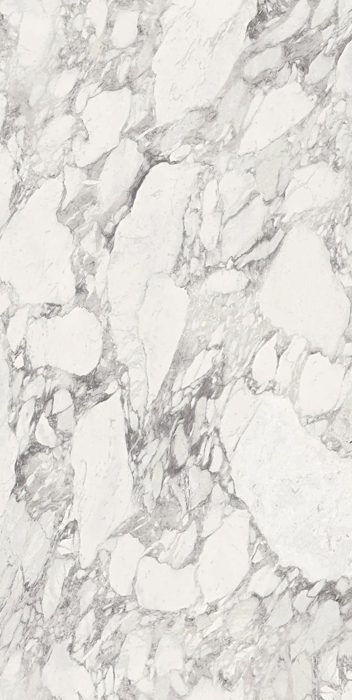 Detailed surface view of white marble look Calacatta Magnifico porcelain slabs with natural veining.