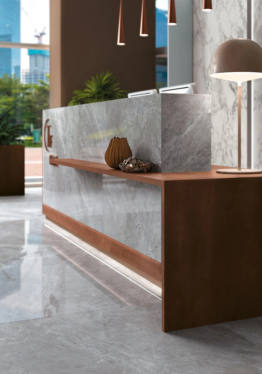 Tundra Select porcelain slabs used on modern reception desk with warm wood accents and pendant lights.