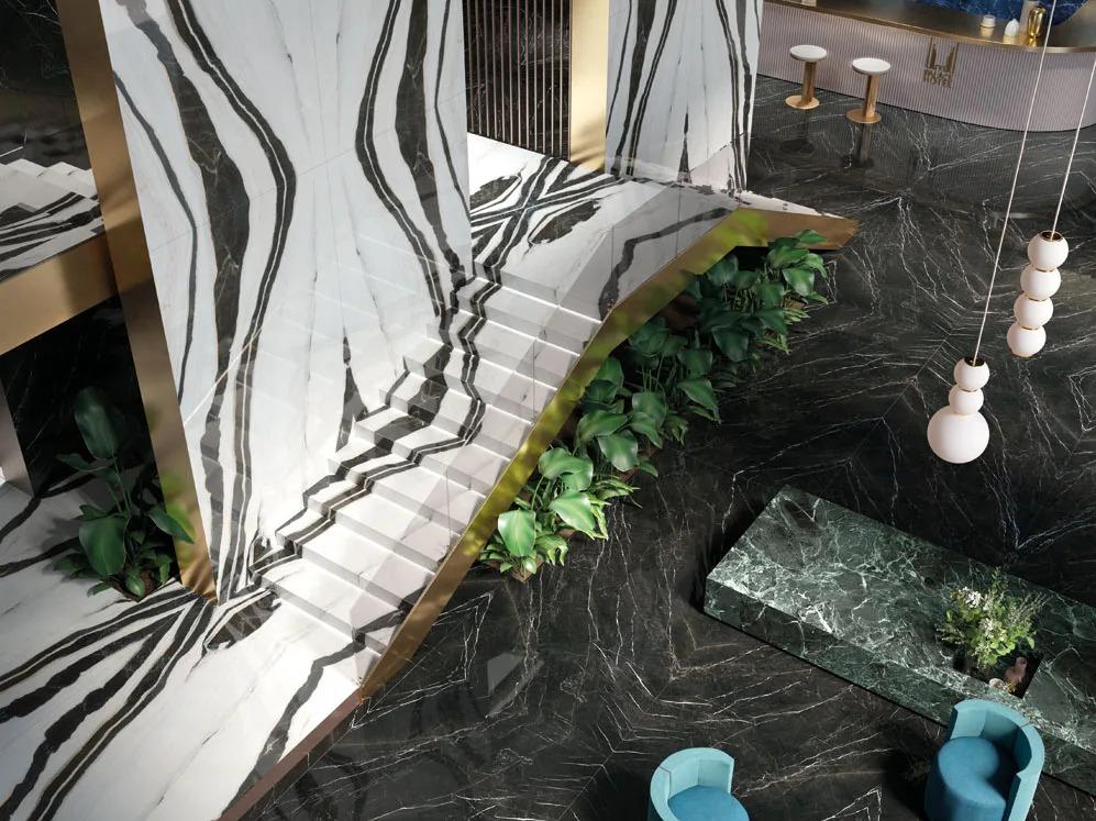 Elegant commercial space showcasing Nero Marquinia porcelain slabs with curved staircase and gold details.