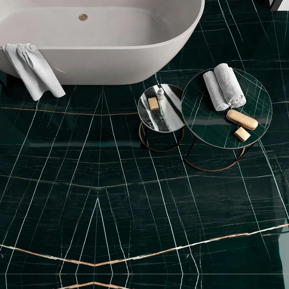 Luxury bathroom floor using Sahara Noir porcelain slabs with gold veins and freestanding white tub.