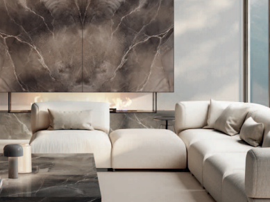 Pietra Grey porcelain slabs installed on feature wall behind cream sectional sofa in luxury home.