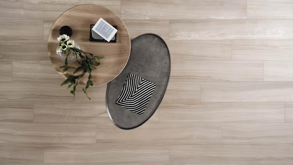Modern living room with an overhead view of light-colored travertine look subway tile for kitchen or living area flooring, featuring minimalist coffee tables.