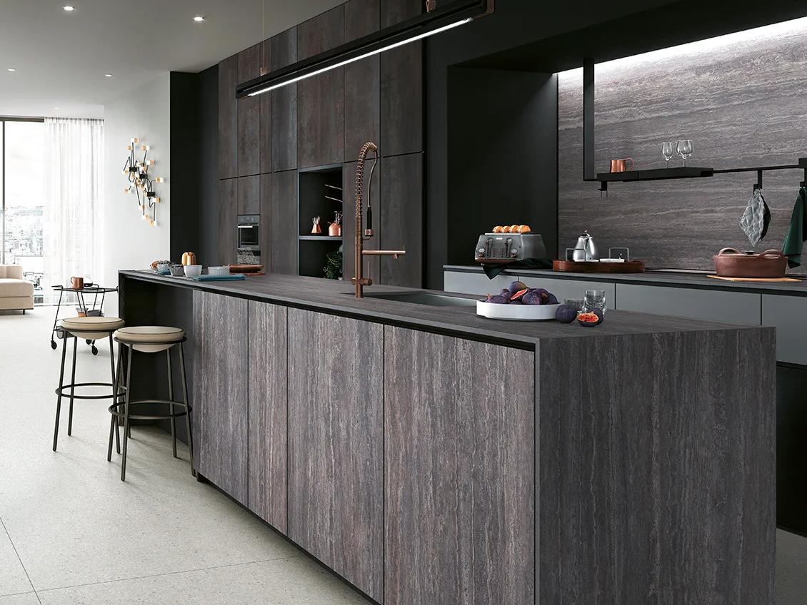 Travertino Grey porcelain slabs throughout modern kitchen design featuring dark tones and linear texture pattern.