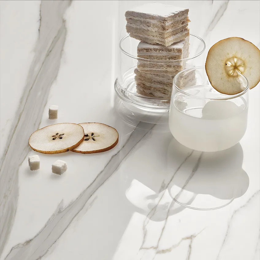 Défense porcelain slabs countertop with layered dessert, fruit slices, and white glass containers.