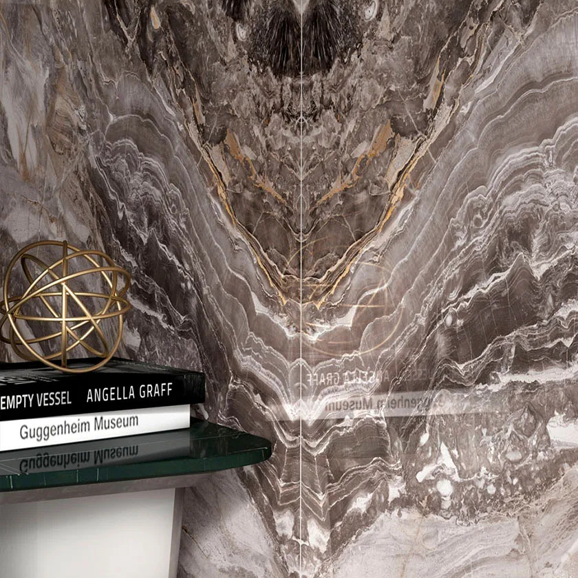 Orobico Luxe porcelain slabs installed as corner wall with decorative books and gold accents.