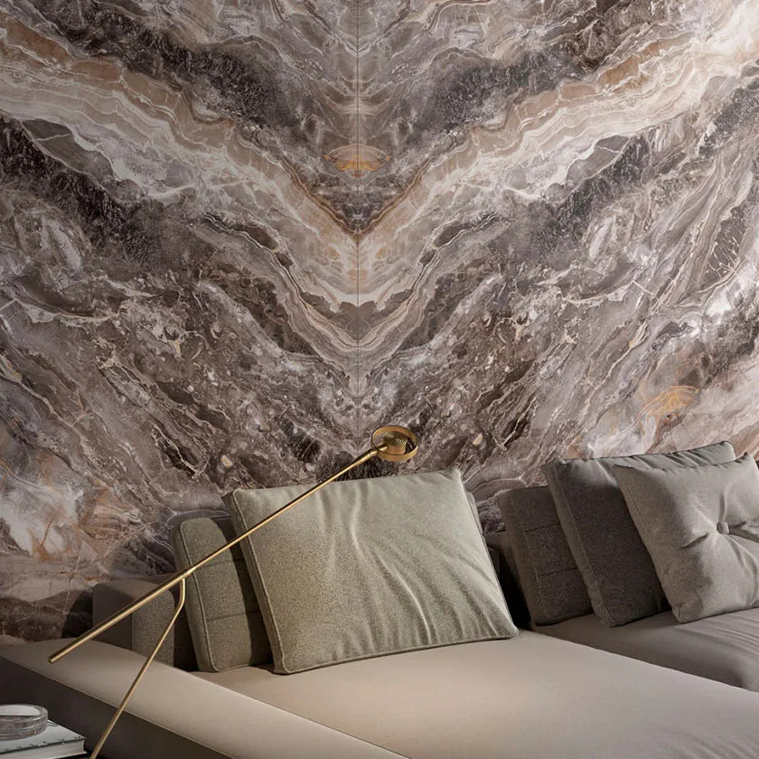 Luxury interior with Orobico Luxe porcelain slabs showing grey and golden veining patterns.