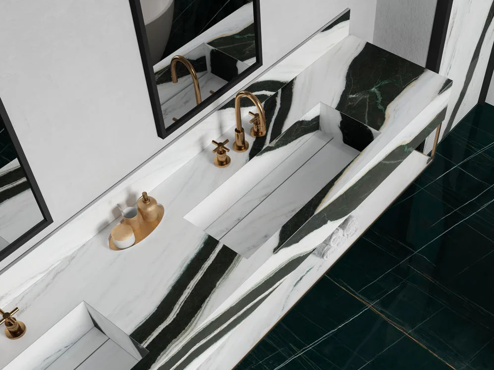 Bathroom vanity with Panda White porcelain Slabs countertop and gold faucet fixtures.