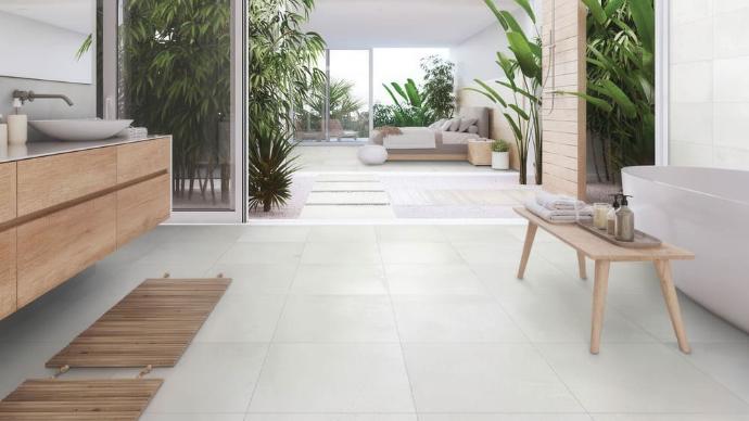 Gotham Pearl 24x24 matte cement-look porcelain tiles in a large, airy spa-style bathroom with indoor plants and a light wood vanity.