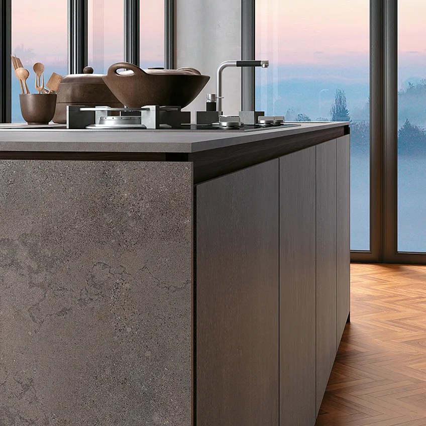 Kitchen island featuring Buxy Select porcelain slabs with waterfall edge and copper cookware on top.