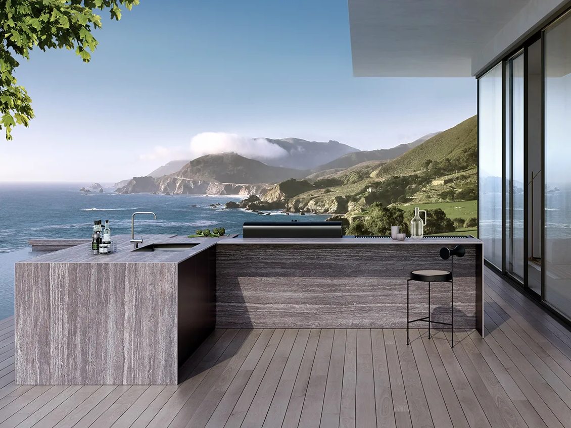 Outdoor kitchen featuring Travertino Grey porcelain slabs island with stunning ocean and mountain cliff views.