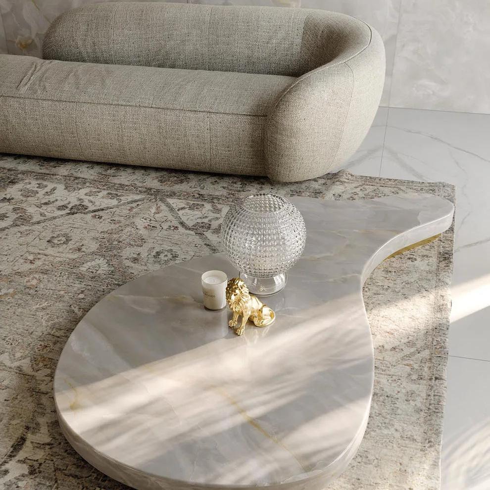 Onyx White porcelain slabs coffee table with curved sofa in modern living room.