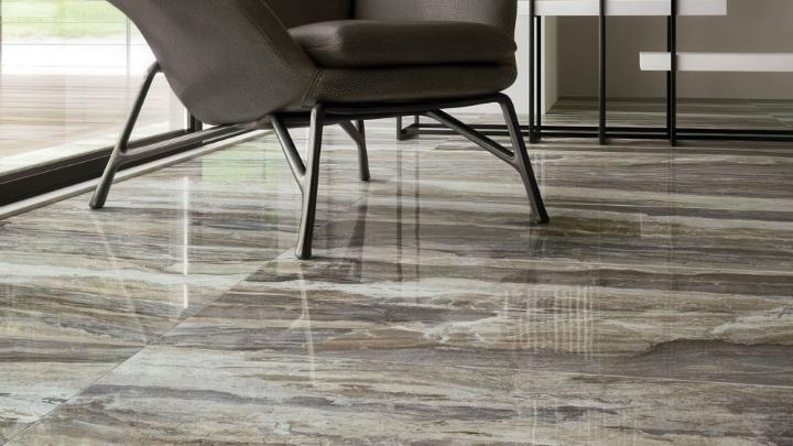 Modern sunlit lounge area featuring polished serene taupe flooring porcelain tile with natural stone veining.