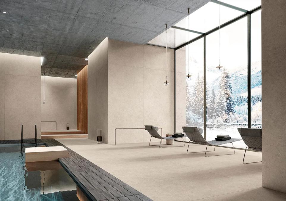 Large format ivory porcelain tile on floors and walls in a luxury indoor spa with pool