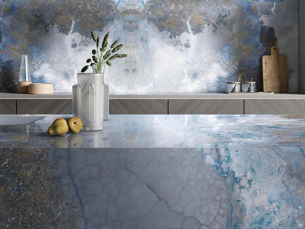 Modern kitchen featuring Thunderstorm porcelain slabs with blue veining on countertops and wall.