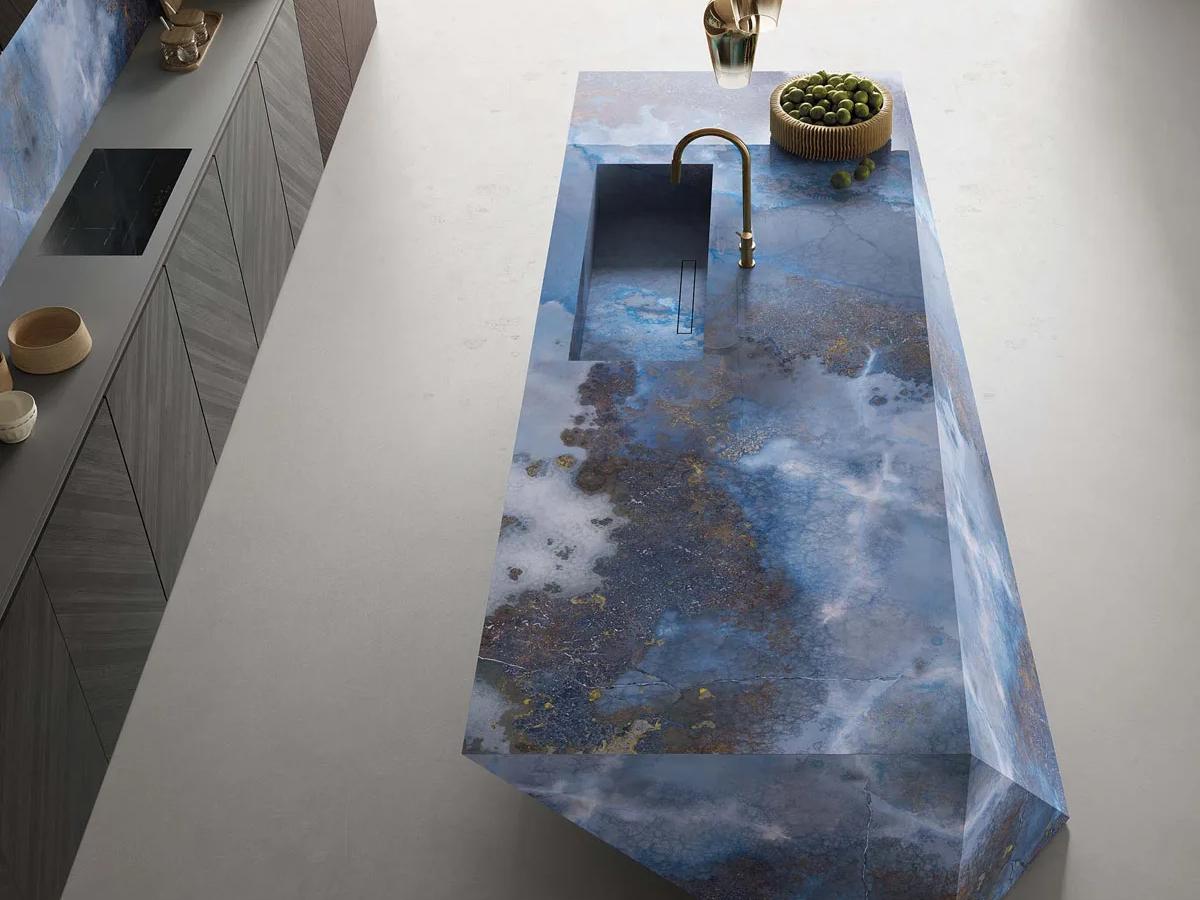Kitchen island featuring Thunderstorm porcelain slabs with striking stormy blue marble effect surface.