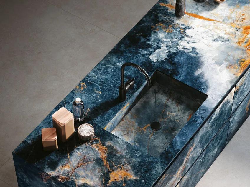 Ocean Blue porcelain slabs installed as kitchen counter featuring integrated black sink.
