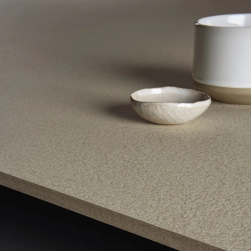 Plaster Ground porcelain slabs used as elegant countertop in modern minimalist kitchen setting.