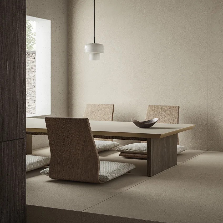 Minimalist living space with Plaster Ground porcelain slabs on walls and neutral flooring.