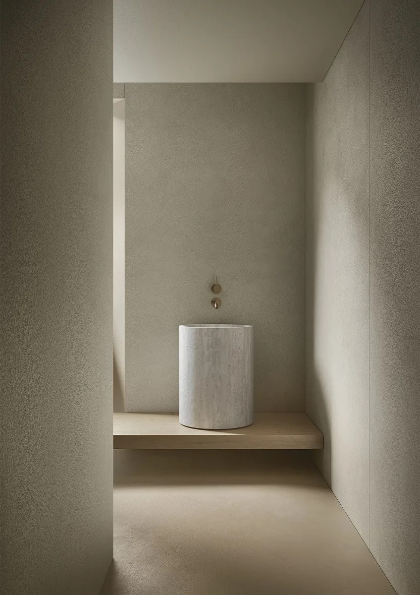 Modern bathroom featuring Plaster Bone porcelain slabs on walls with cylindrical sink.