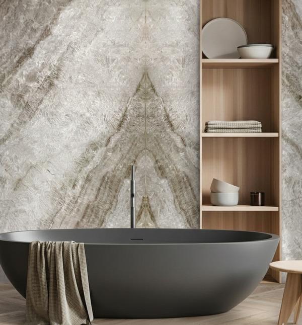 Natural stone feature wall behind a freestanding bathtub.