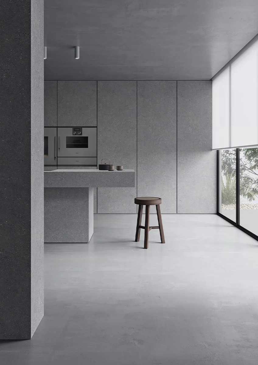Sandstone Gray porcelain slabs used in modern minimalist kitchen with large windows.