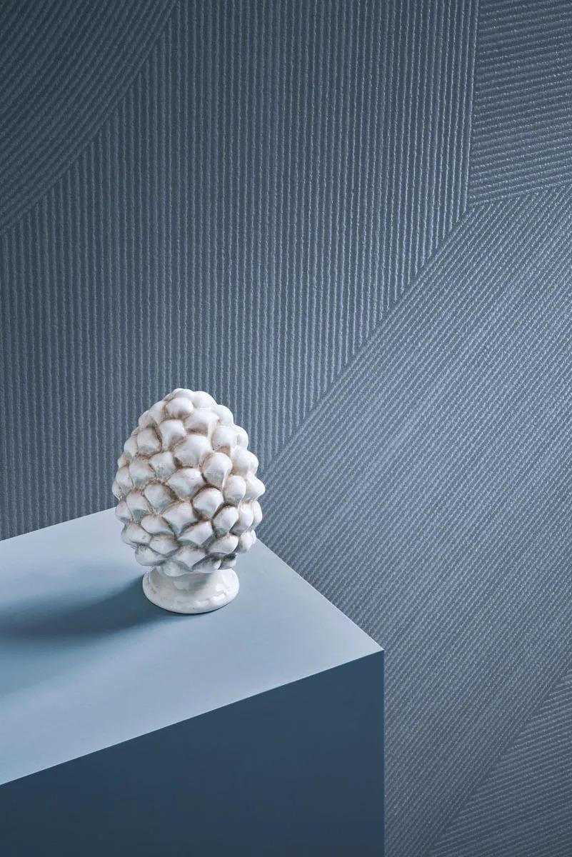 Ginza Sorairo porcelain slabs textured feature wall showcasing white ornamental sculpture on contemporary display stand.