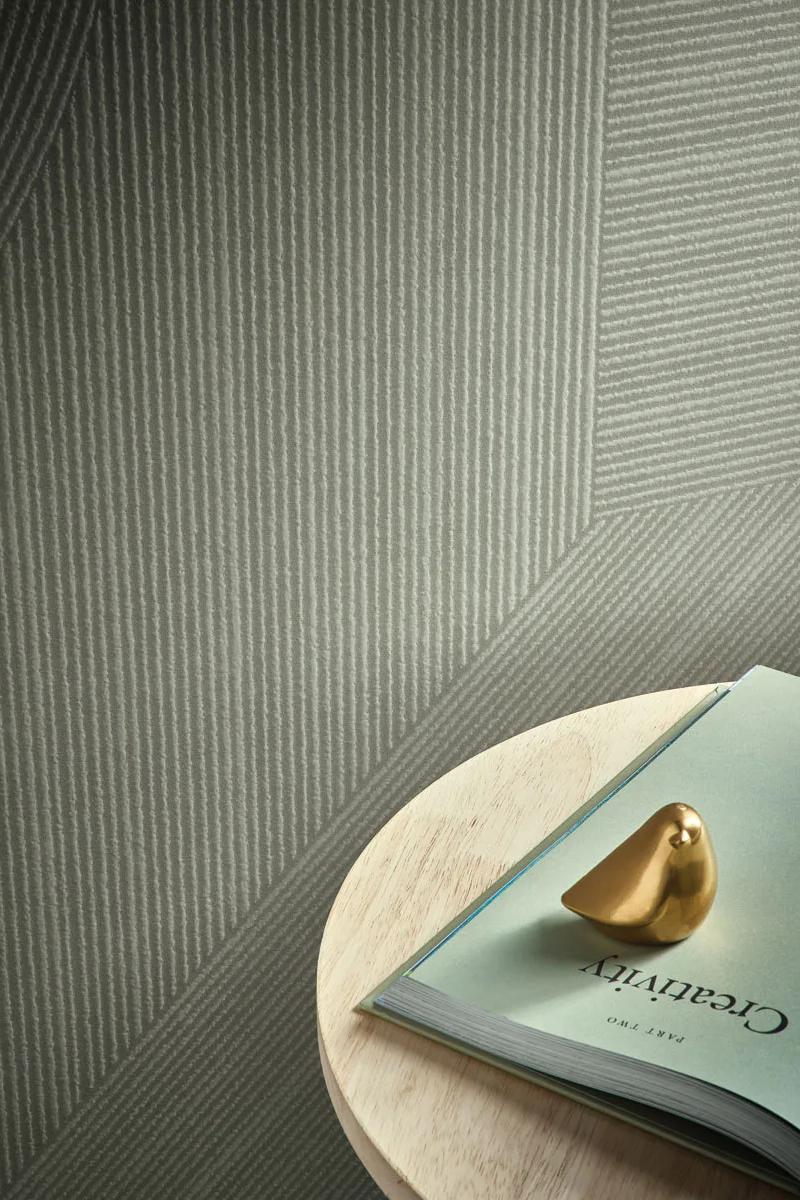 Books and gold decor on a round wooden tray resting on Gordes porcelain slabs.